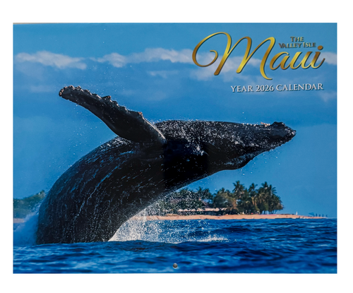 2026 Maui “The Valley Isle” calendar cover featuring a majestic humpback whale breaching in front of a palm-lined Hawaiian shoreline under a clear blue sky.