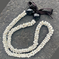 Mongo shell necklace with black pendant on a textured surface