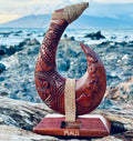 Carved wooden hook with a rope against a scenic background