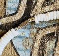 Picture of barrel clasp on handmade shark tooth pendant necklace with 5mm puka shells, 18-inch choker style, displayed in natural light with coastal beach backdrop
