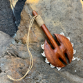 Wooden tool with a rope handle on a rocky surface