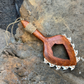 Wooden tool with a rope handle on a rocky surface