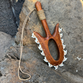 Wooden weapon with shark teeth on a rocky surface