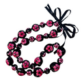 Necklace with pink floral beads and a black ribbon on a white background