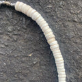 Closeup of White shell necklace on a charcoal background