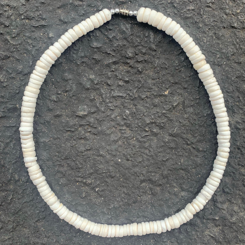 White shell necklace on a charcoal background