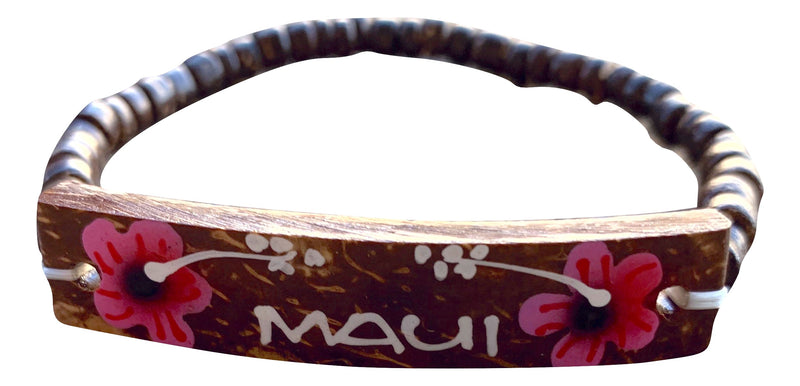 A coconut shell bracelet with hand-painted flowers and the text 'MAUI' on it.