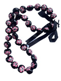 A black and pink kukui nut lei with a floral pattern and an adjustable black ribbon closure.