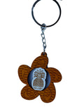 Wooden Hawaiian keychain featuring a plumeria blossom shape with a carved pineapple center design, lightweight and tropical style.