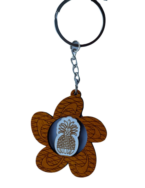 Wooden Hawaiian keychain featuring a plumeria blossom shape with a carved pineapple center design, lightweight and tropical style.