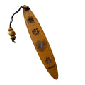 A collection of wooden bookmarks with Hawaiian inspired designs, featuring phrases and images related to Hawaii, displayed on a surface with a floral patterned book in the background.