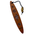 A collection of wooden bookmarks with Hawaiian inspired designs, featuring phrases and images related to Hawaii, displayed on a surface with a floral patterned book in the background.