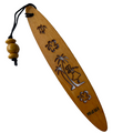 A collection of wooden bookmarks with Hawaiian inspired designs, featuring phrases and images related to Hawaii, displayed on a surface with a floral patterned book in the background.